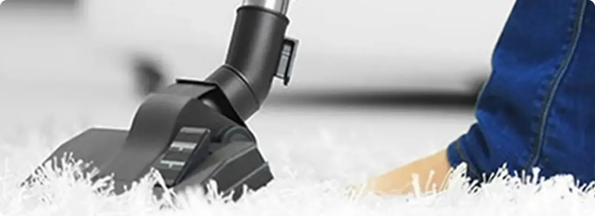 Close-up of a professional vacuuming a white carpet in Willow.